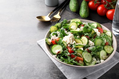 Photo of Plate of delicious cucumber salad served on grey table. Space for text