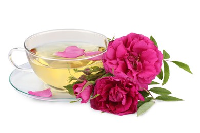Photo of Aromatic herbal tea in glass cup, peonies and green leaves isolated on white