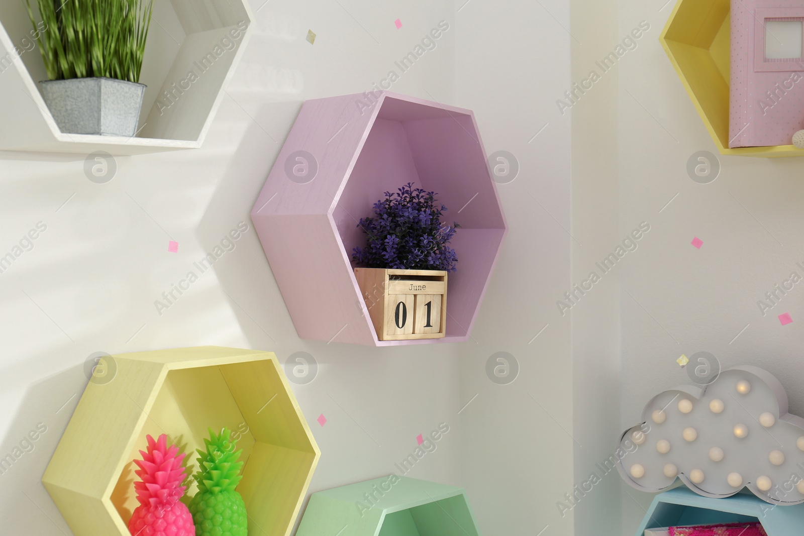 Photo of Hexagon shaped shelves on white wall. Interior design