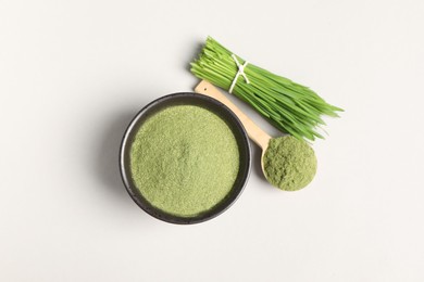 Wheat grass powder and fresh green sprouts on light table, flat lay