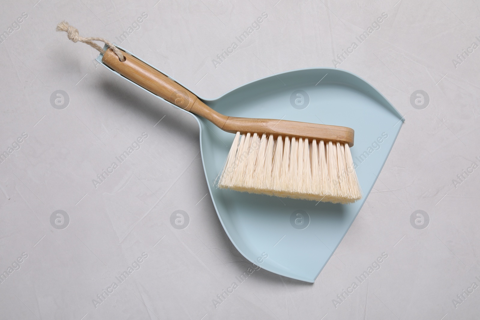 Photo of Cleaning brush and scoop on light grey background, top view