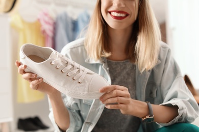Photo of Female fashion blogger with sneaker at home, closeup