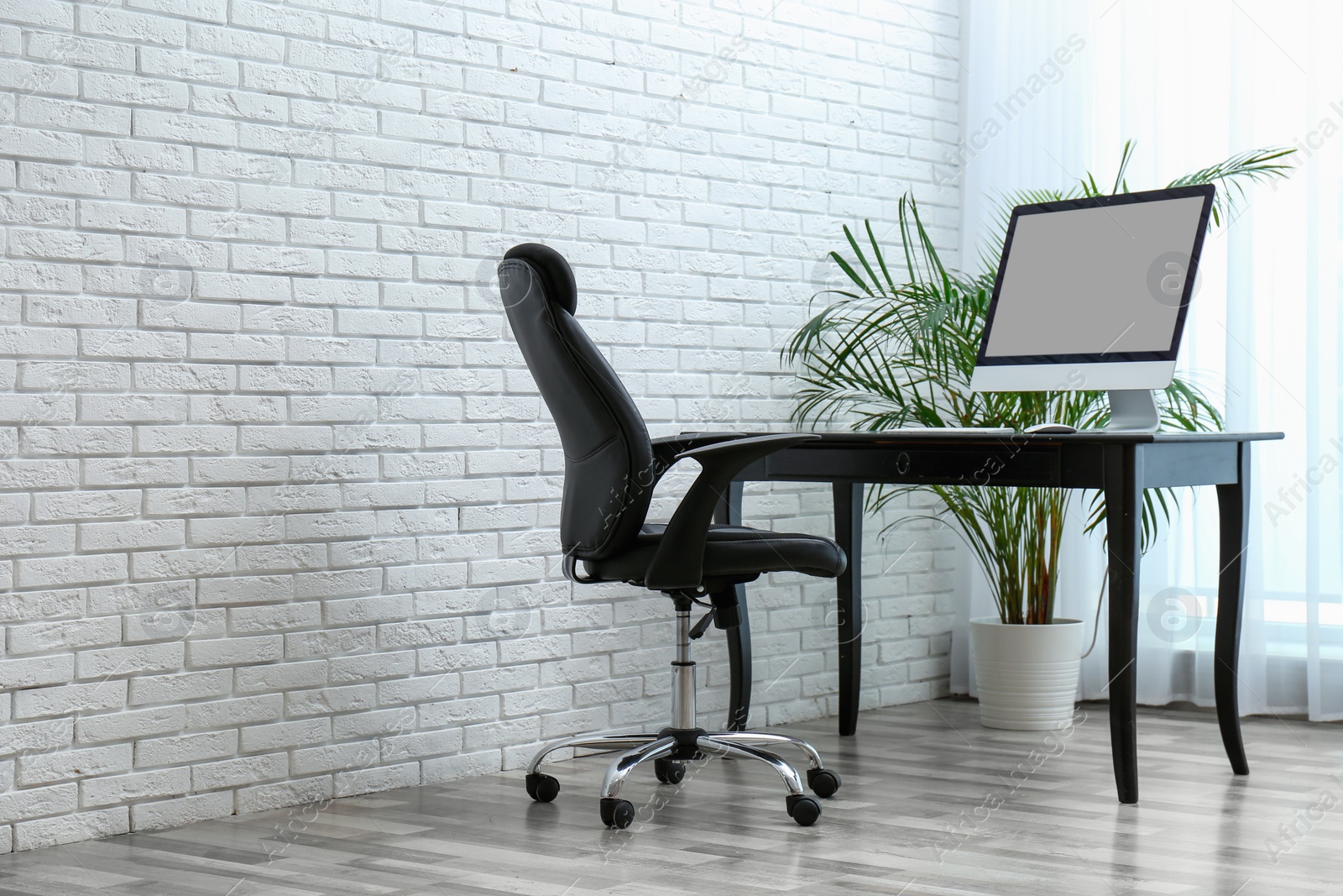 Photo of Stylish workplace interior with modern office chair