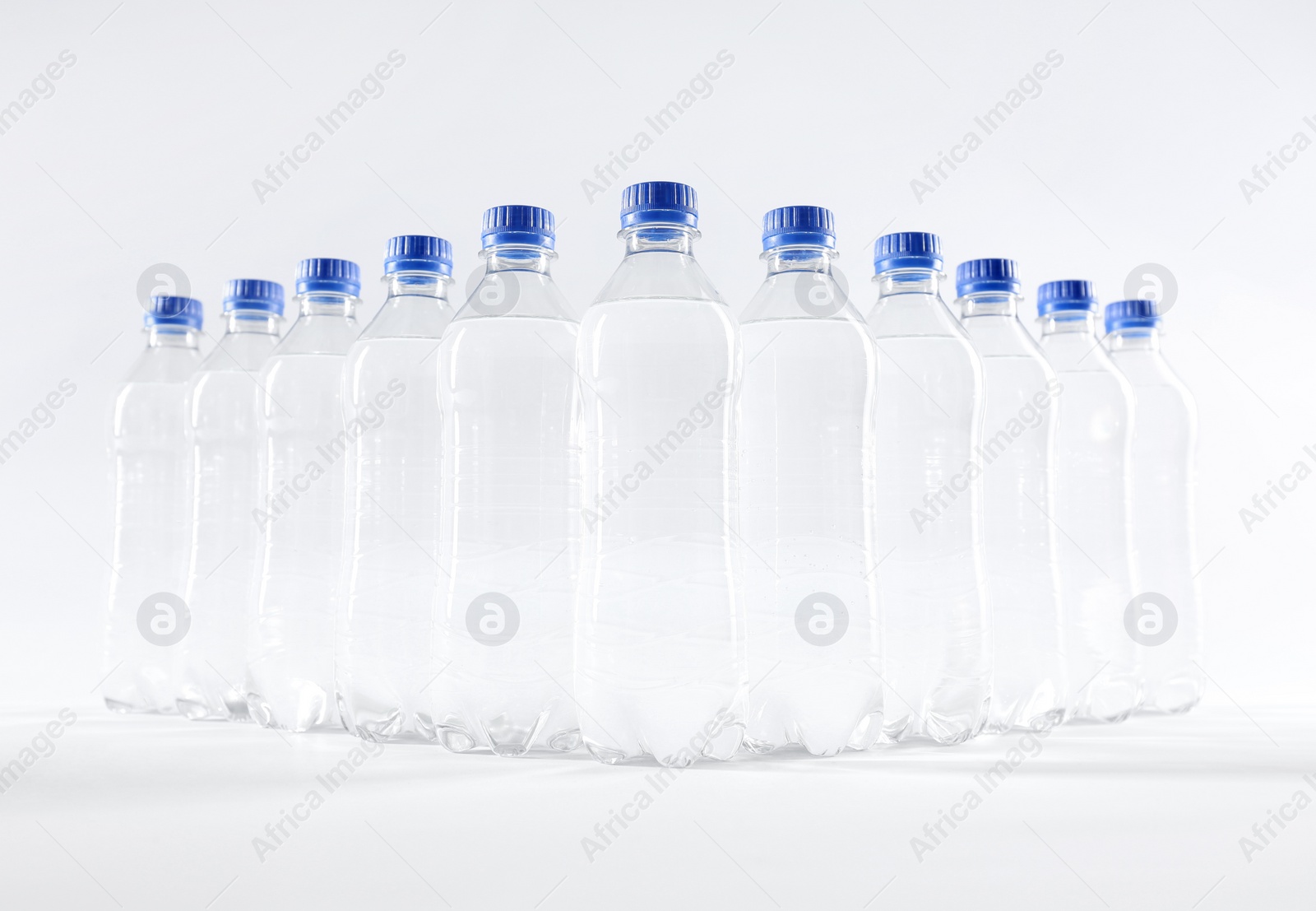 Photo of Plastic bottles with pure water on white background