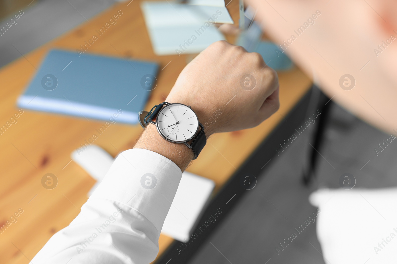 Photo of Man checking time in office, closeup. Being late