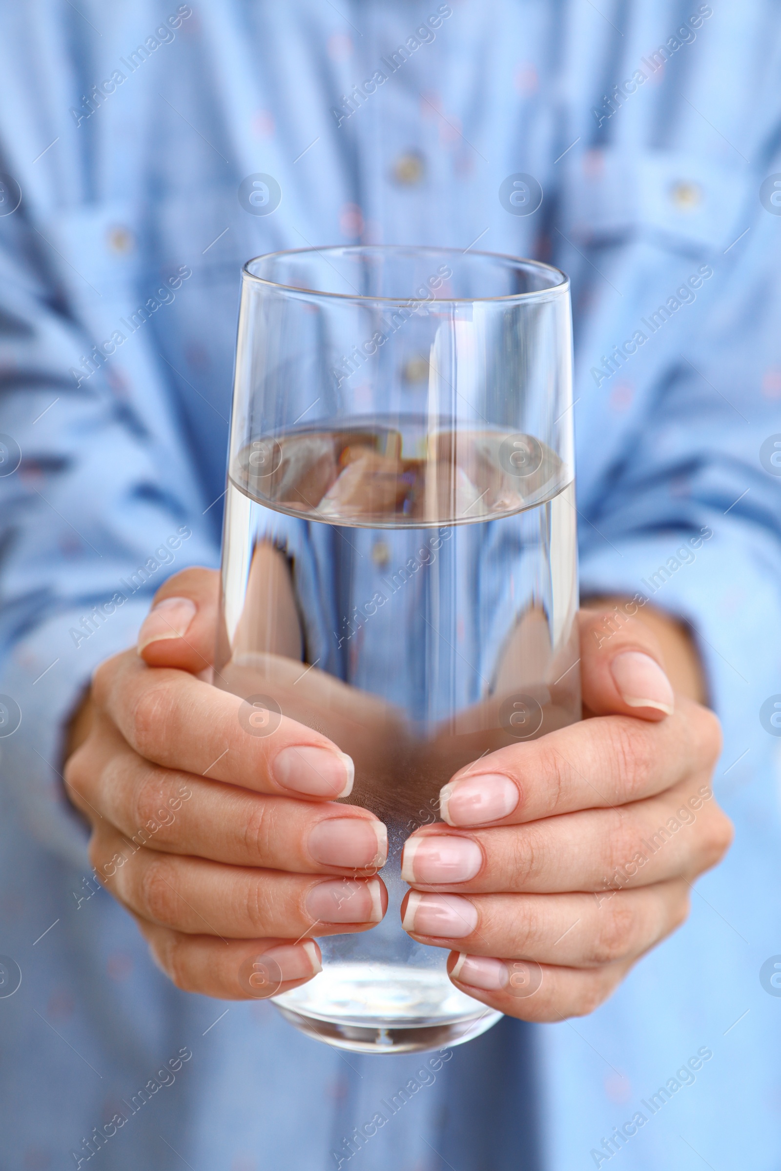 Photo of Woman holding glass of water, closeup. Refreshing drink