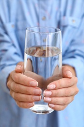 Photo of Woman holding glass of water, closeup. Refreshing drink