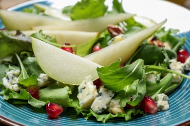 Photo of Fresh salad with pear slices on plate, closeup