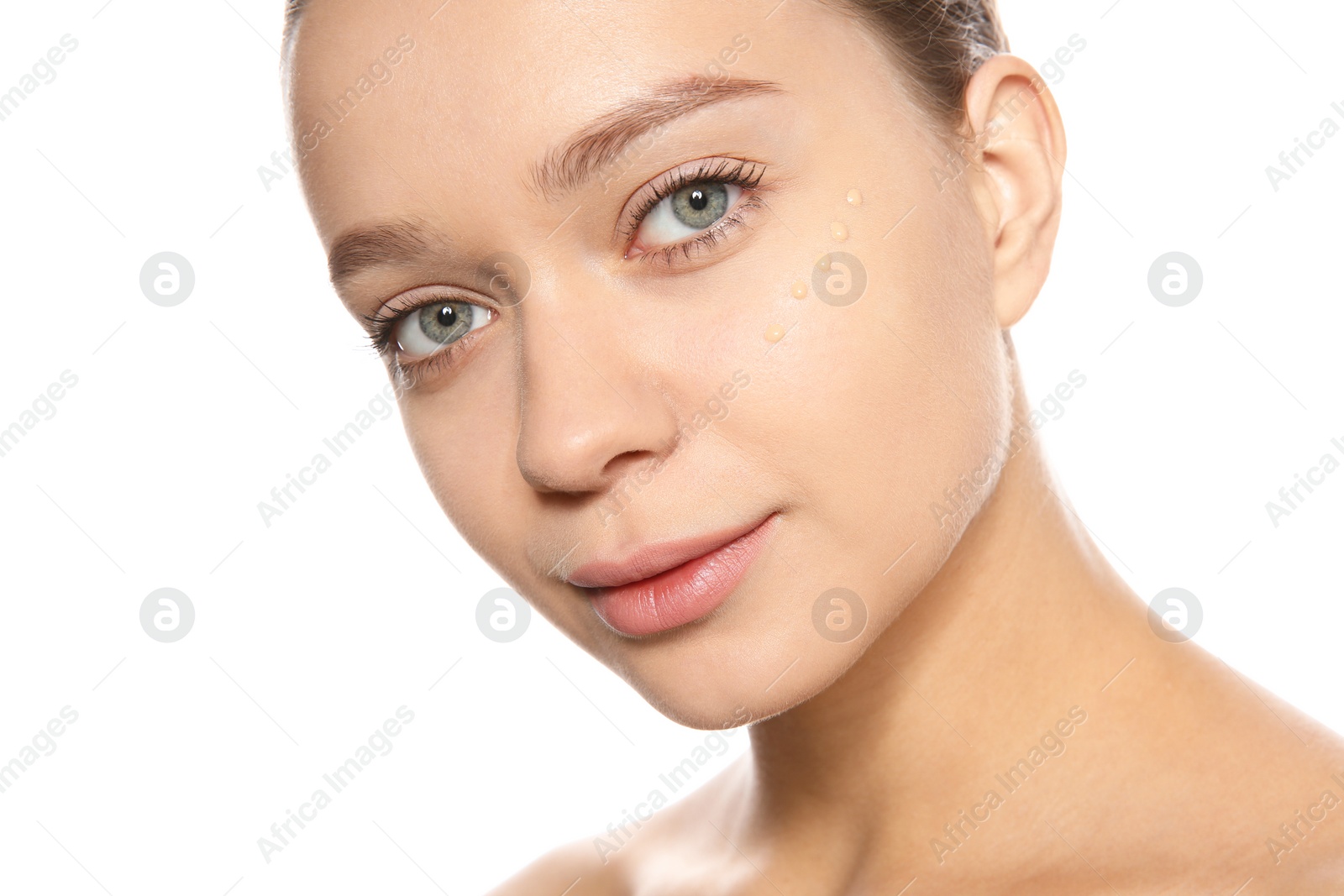 Photo of Portrait of young woman with liquid foundation on her face against white background