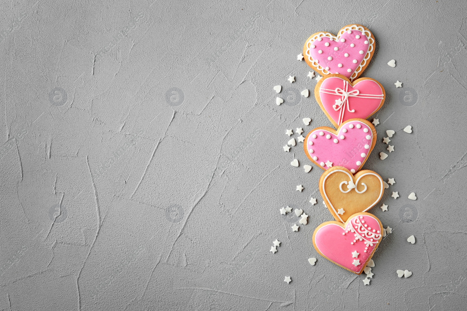 Photo of Flat lay composition with decorated heart shaped cookies and space for text on table