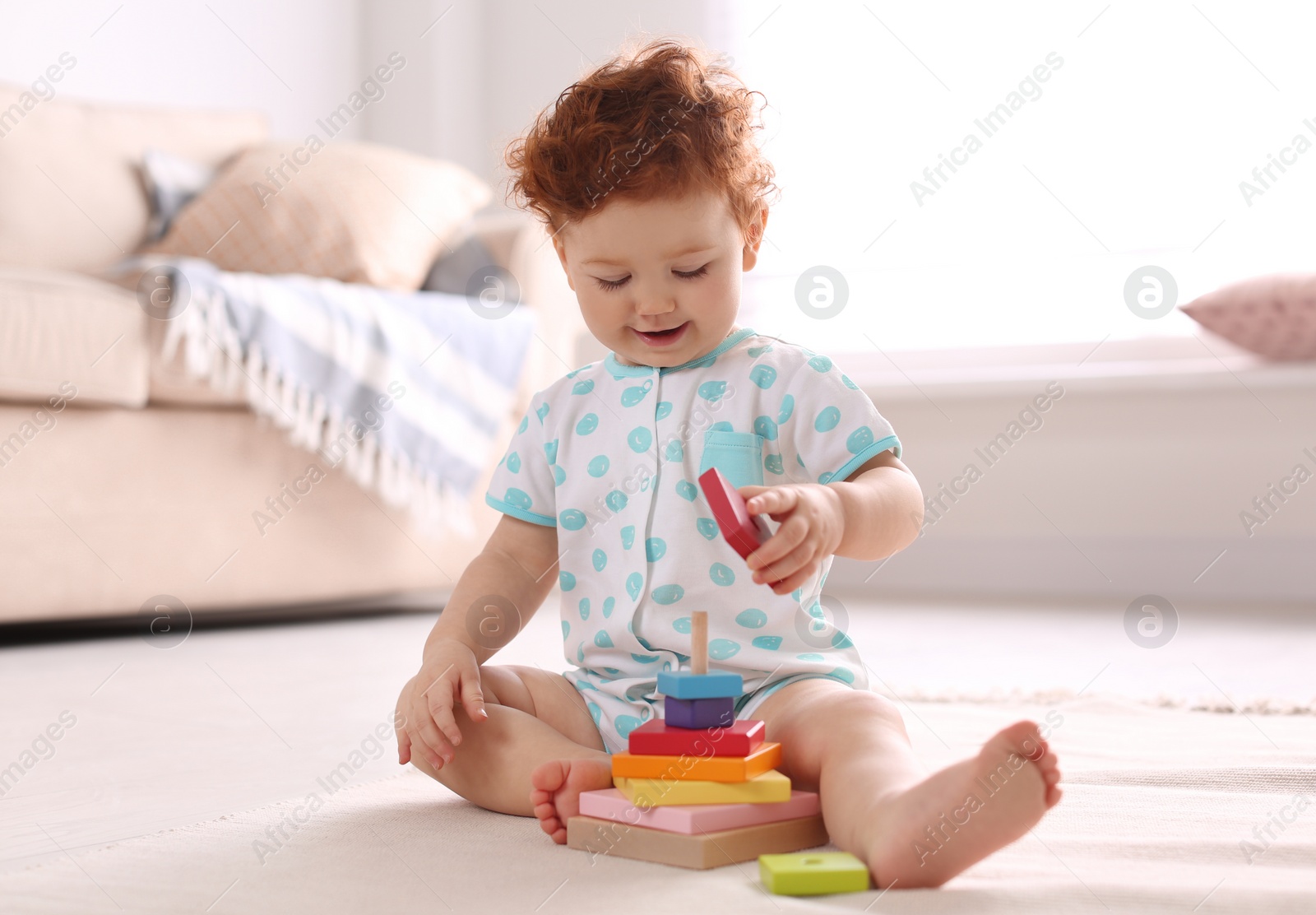 Photo of Cute little child playing with toy on floor at home