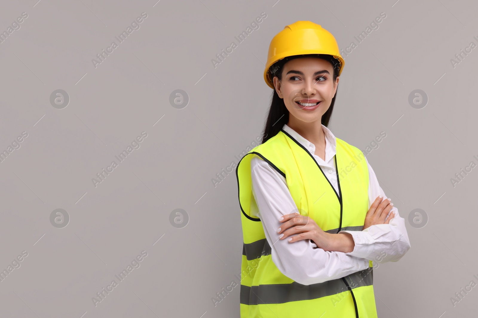 Photo of Engineer in hard hat on grey background, space for text