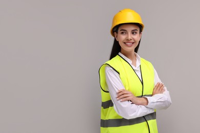 Photo of Engineer in hard hat on grey background, space for text