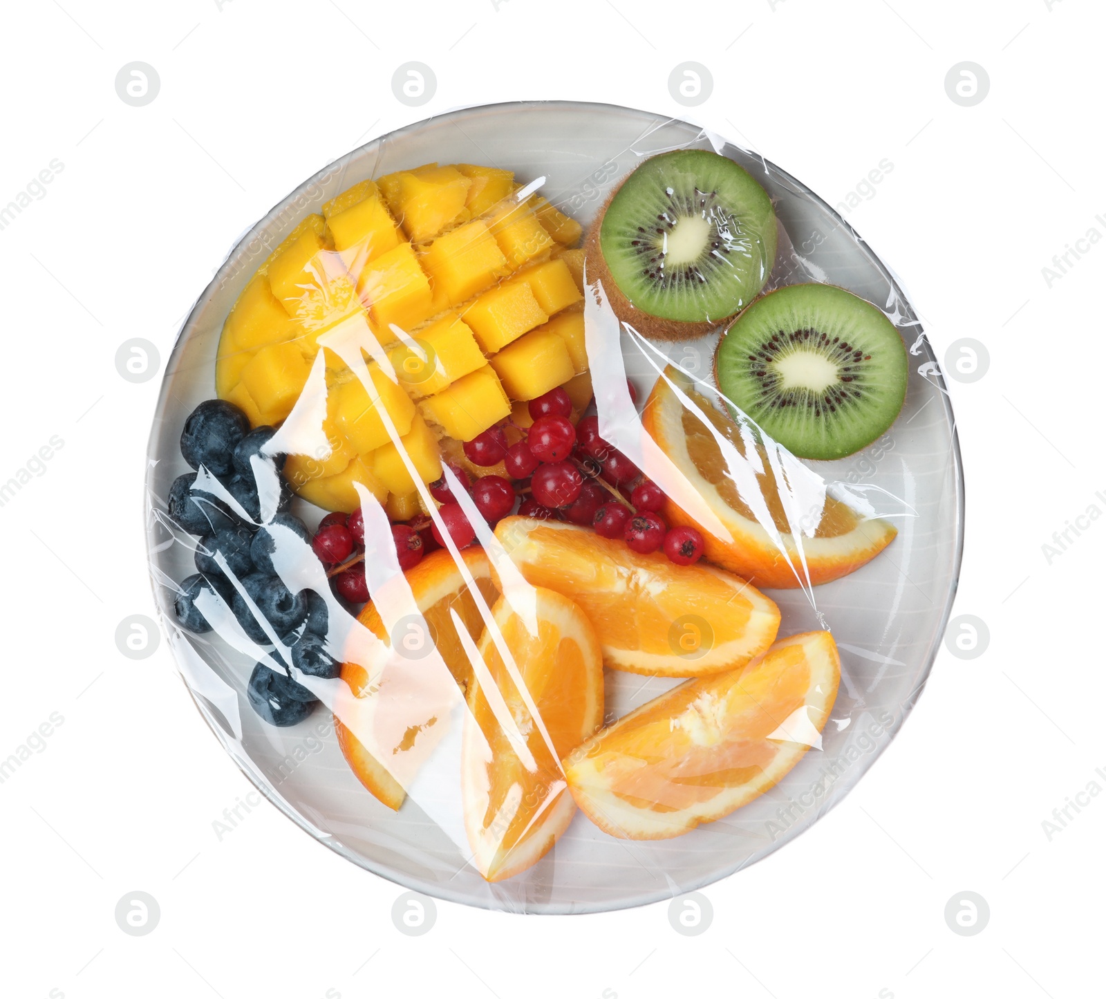 Photo of Plate of cut fruits wrapped with transparent plastic stretch film isolated on white, top view