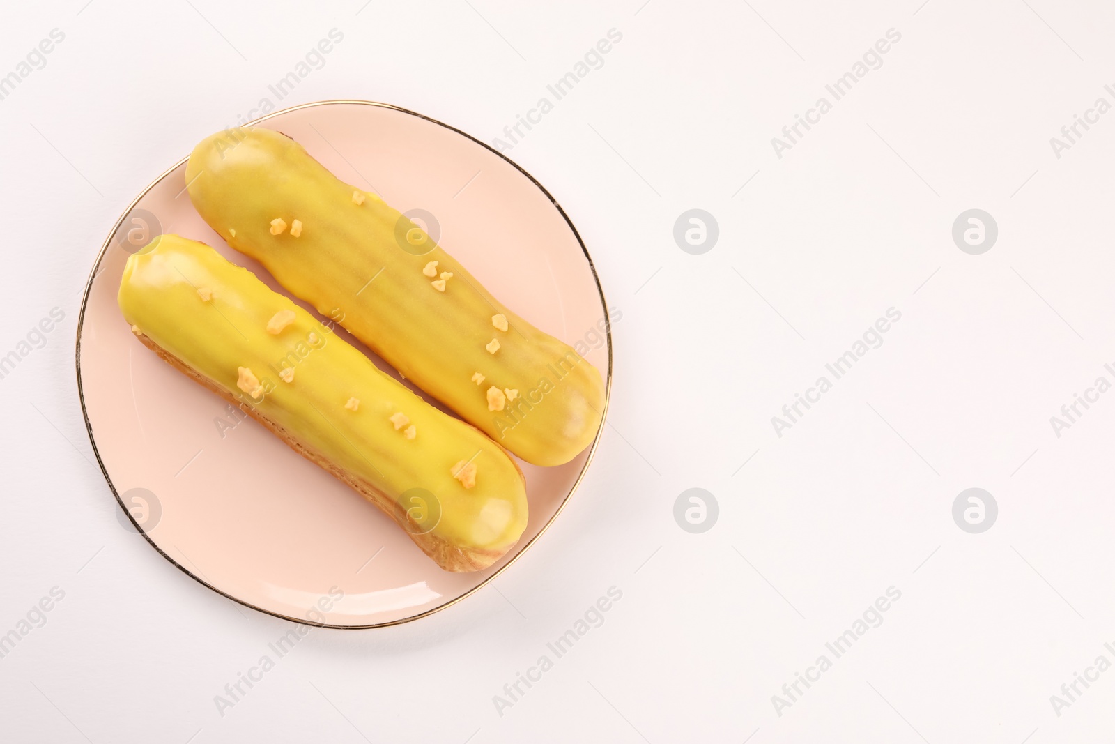 Photo of Delicious eclairs covered with glaze on white background, top view