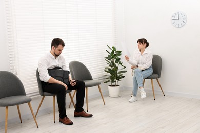 Photo of Man and woman waiting for job interview indoors