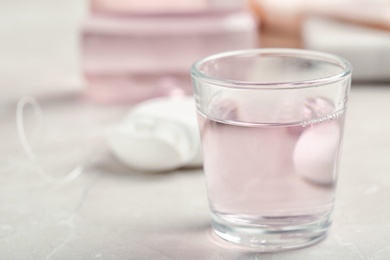 Photo of Glass with mouthwash on light background, closeup. Teeth care