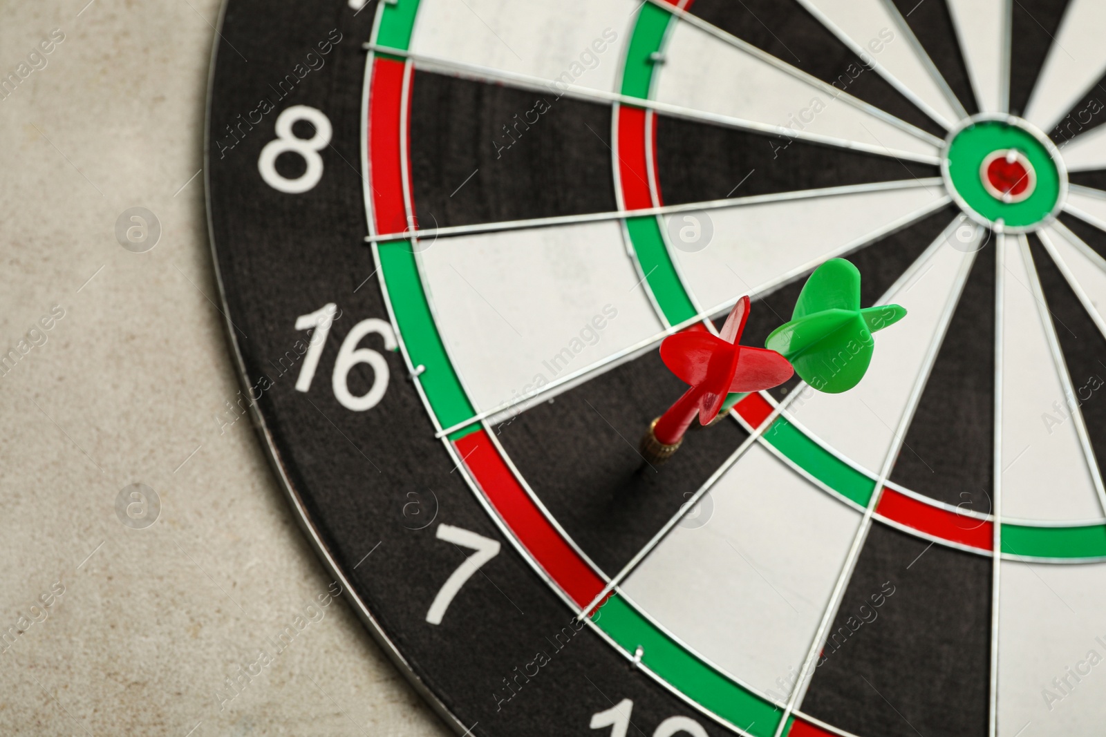 Photo of Dart board with color arrows on light stone background