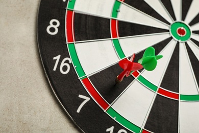 Dart board with color arrows on light stone background