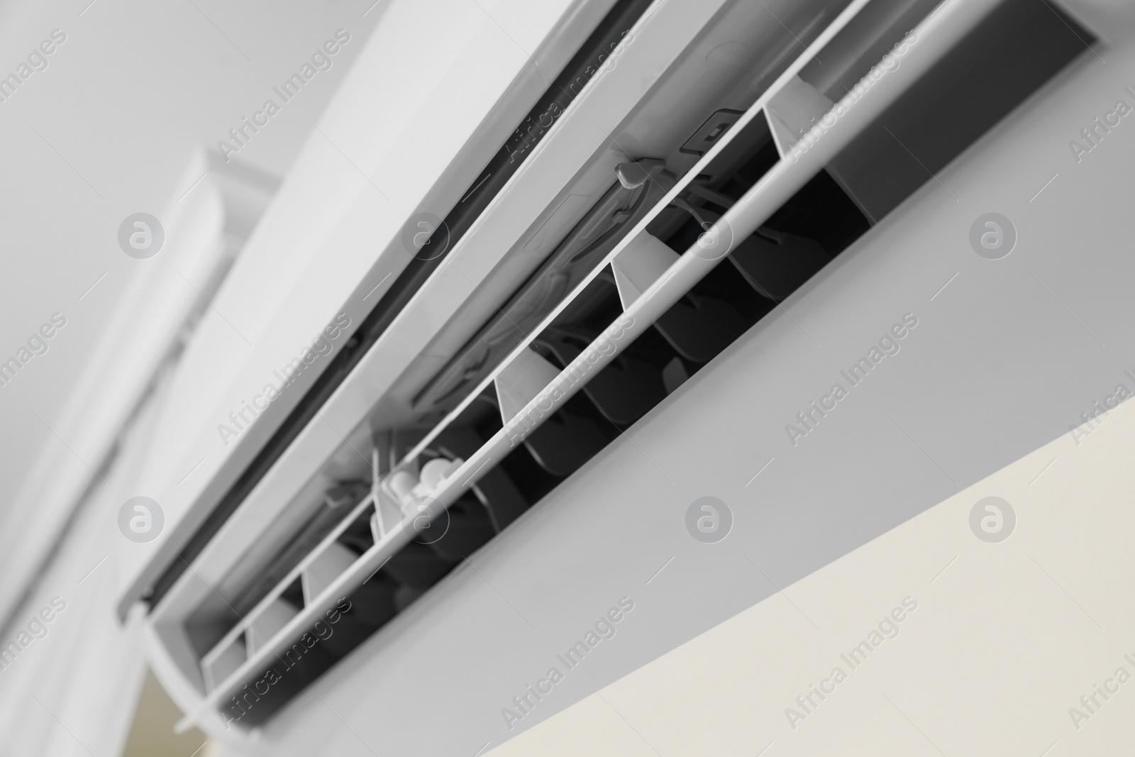 Photo of Modern air conditioner on white wall indoors, closeup view