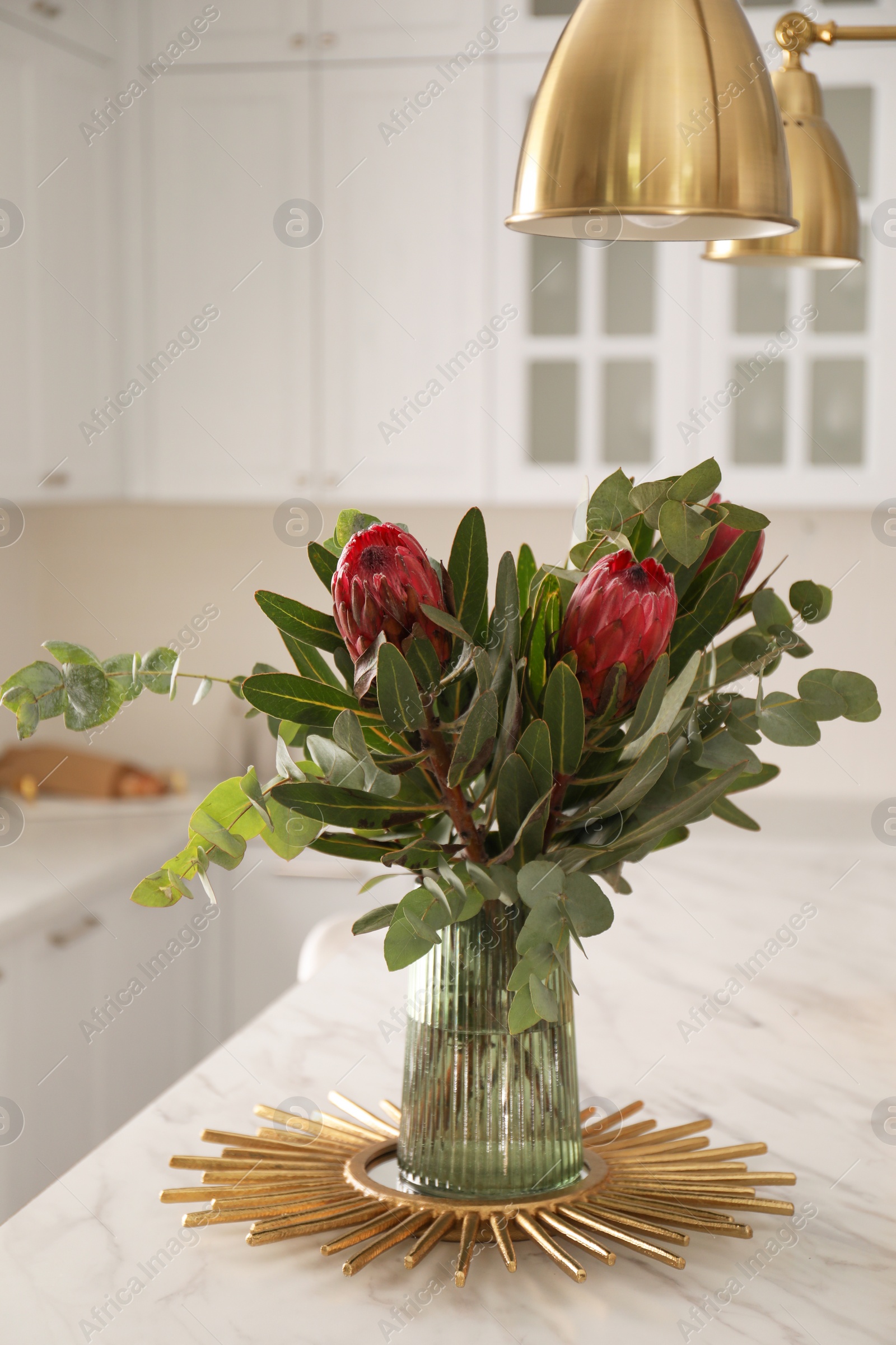 Photo of Bouquet with beautiful protea flowers on table in kitchen. Interior design