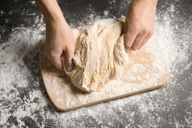 Woman with dough at grey table, top view. Making pasta