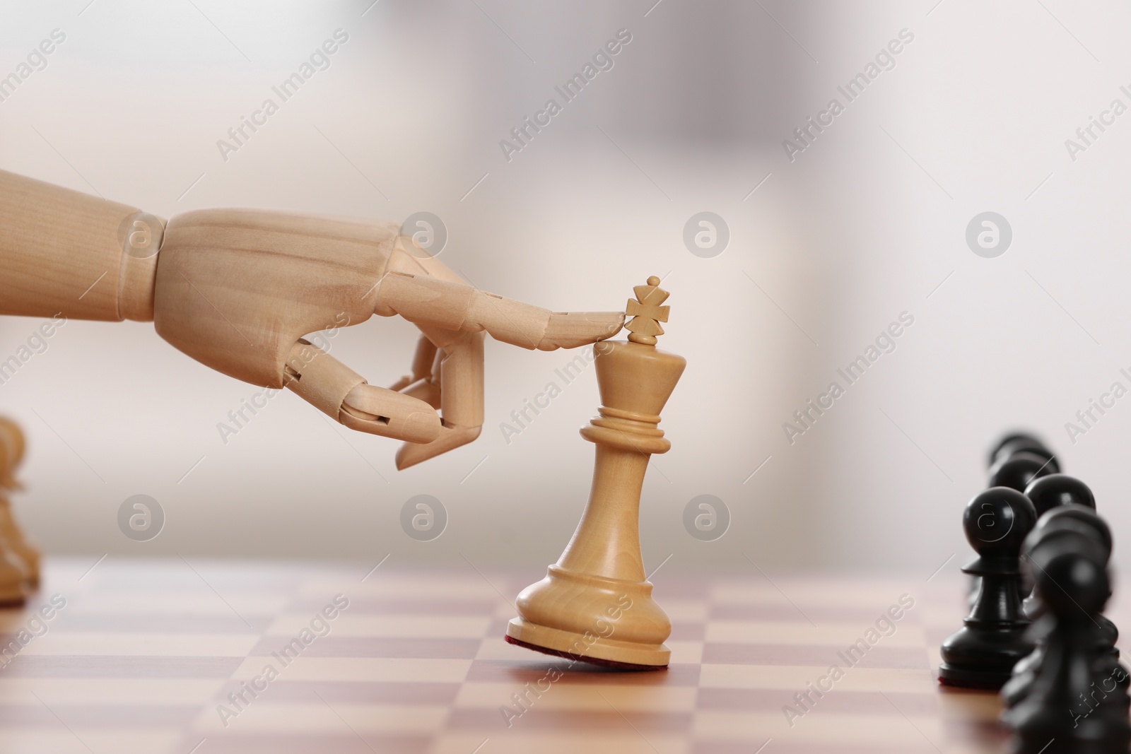 Photo of Robot moving chess piece on board against light background, closeup. Wooden hand representing artificial intelligence