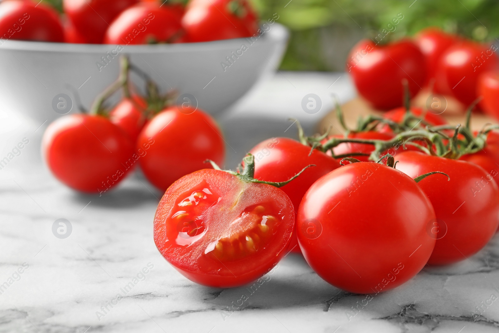 Photo of Branch of fresh cherry tomatoes on marble background