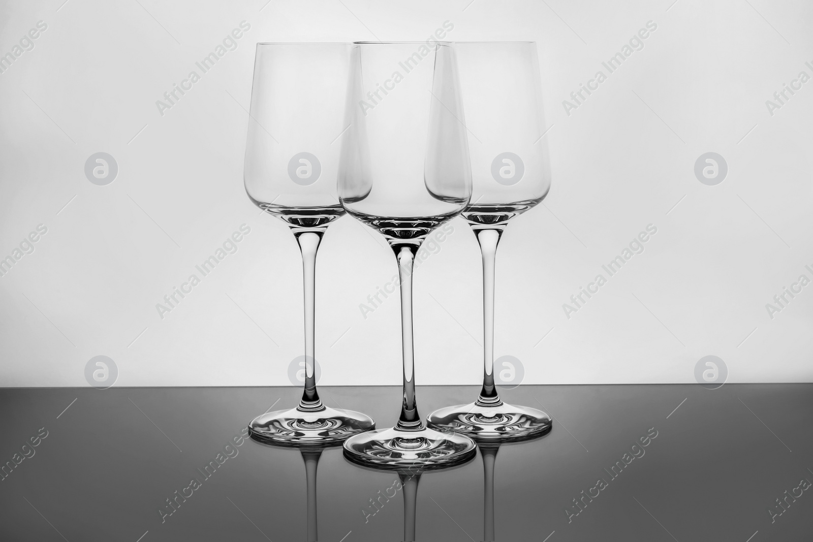 Photo of Empty clear wine glasses on white background