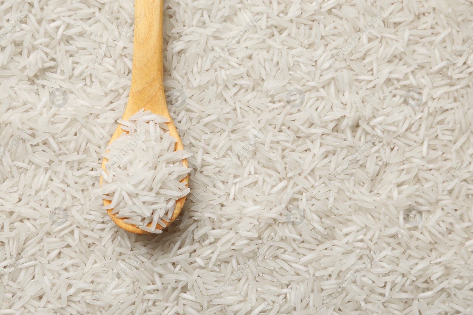 Photo of Raw basmati rice and spoon, top view. Space for text