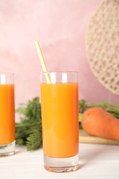 Photo of Freshly made carrot juice on white wooden table