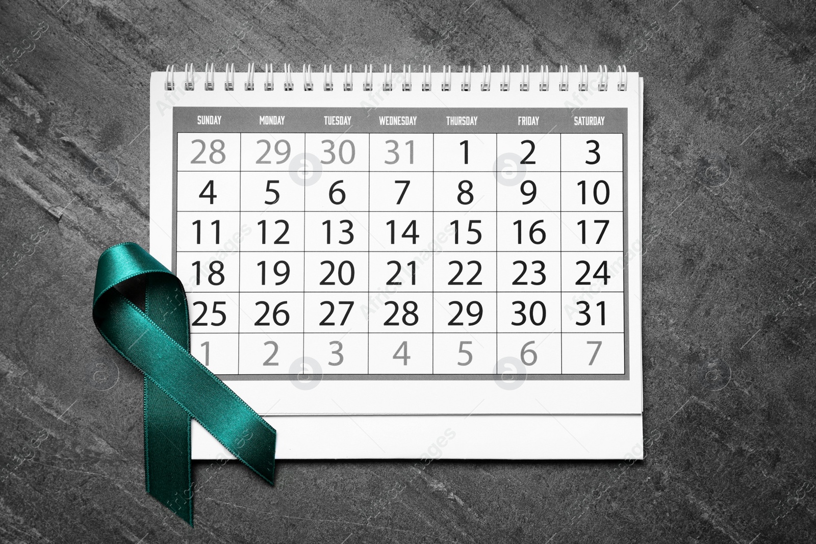 Photo of Flat lay composition with teal ribbon and calendar on grey background