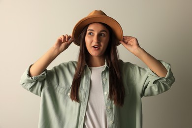 Photo of Surprised young woman in stylish outfit on light background