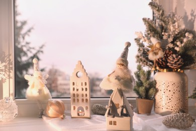 Photo of Many beautiful Christmas decorations and fir branches on window sill indoors