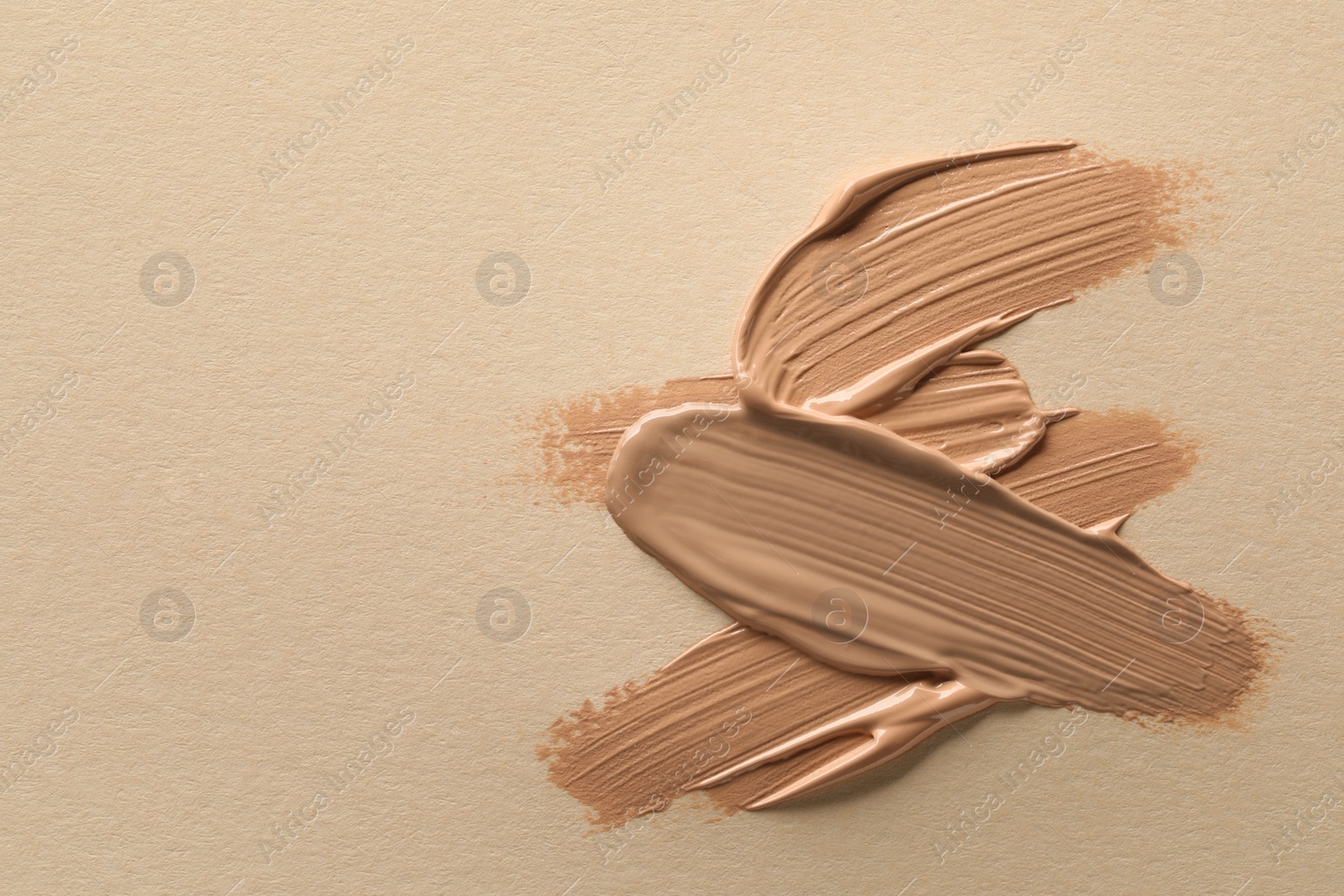 Photo of Samples of liquid skin foundations on beige background, top view. Space for text