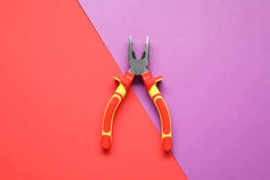 Photo of Combination pliers on color background, top view