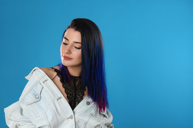 Photo of Young woman with bright dyed hair on blue background, space for text