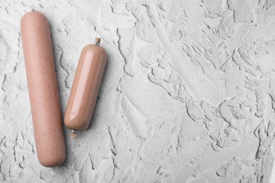 Delicious liver sausages on white textured table, flat lay. Space for text