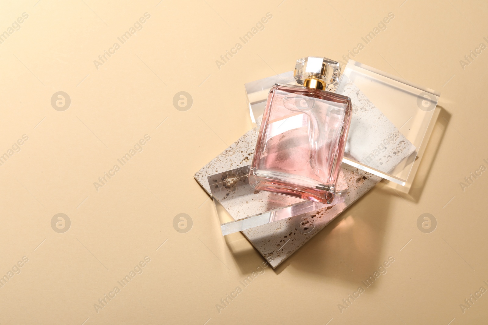 Photo of Stylish presentation of luxury women`s perfume in sunlight on beige background, flat lay. Space for text