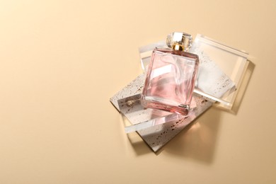 Photo of Stylish presentation of luxury women`s perfume in sunlight on beige background, flat lay. Space for text