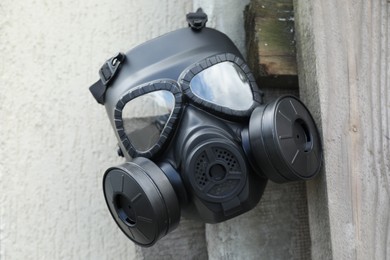 Photo of One gas mask hanging on building outdoors. Safety equipment