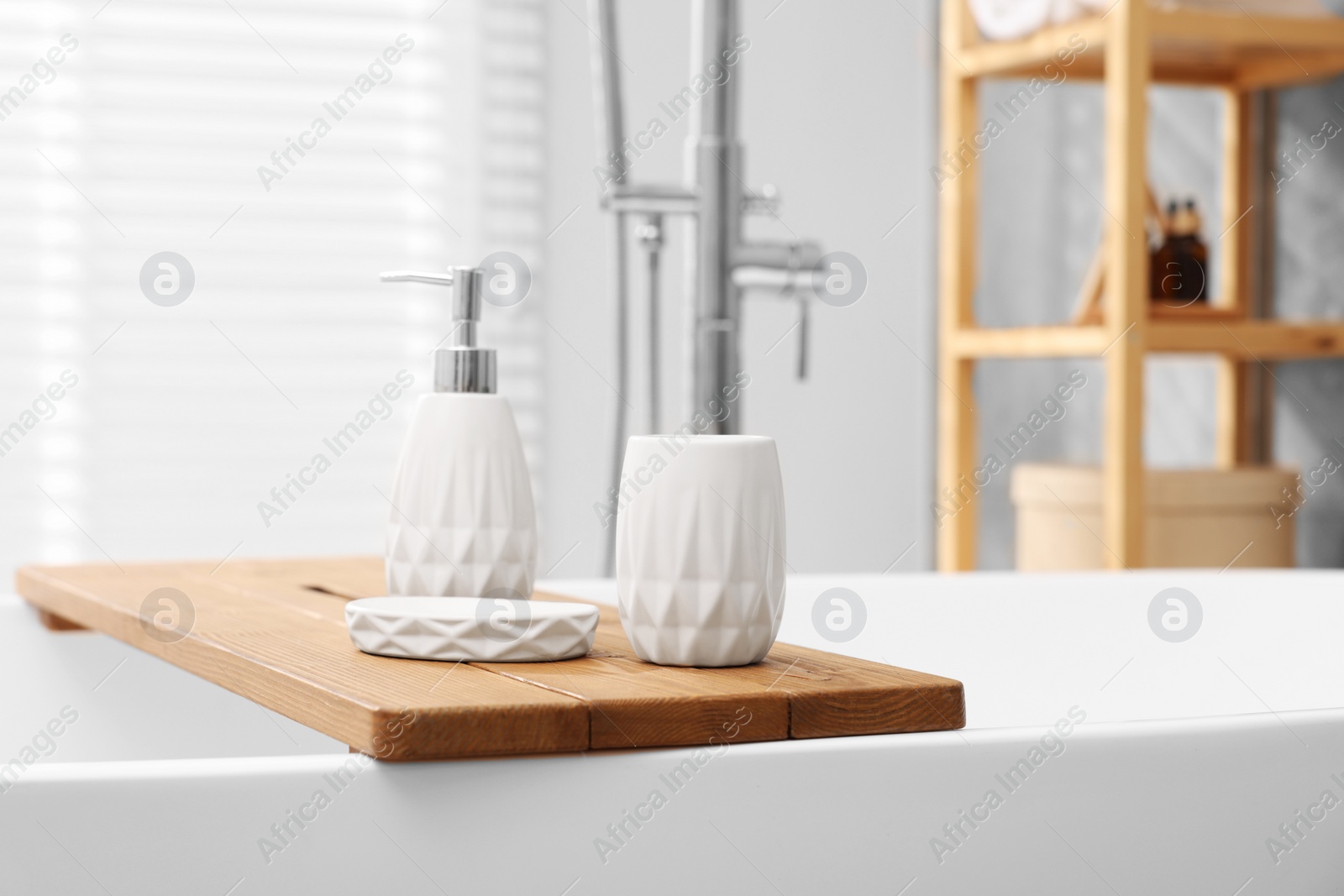 Photo of Set of bath accessories on tub in bathroom