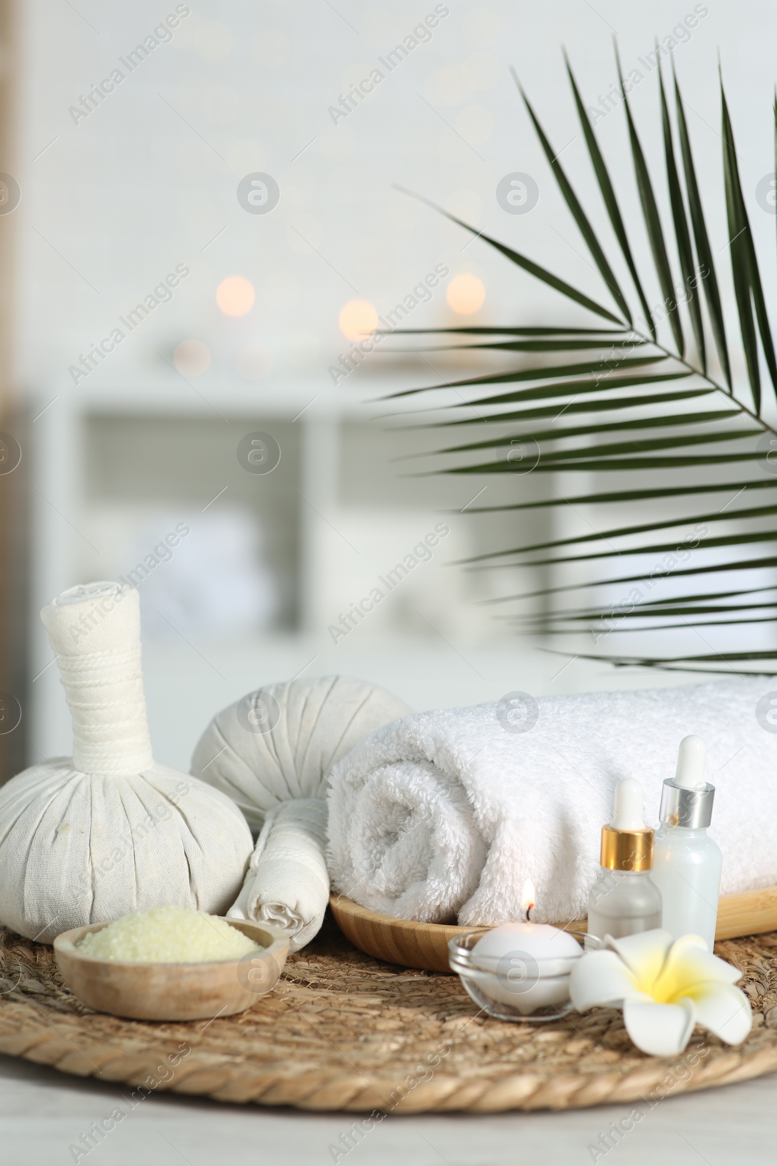 Photo of Composition with different spa products and plumeria flower on white table indoors