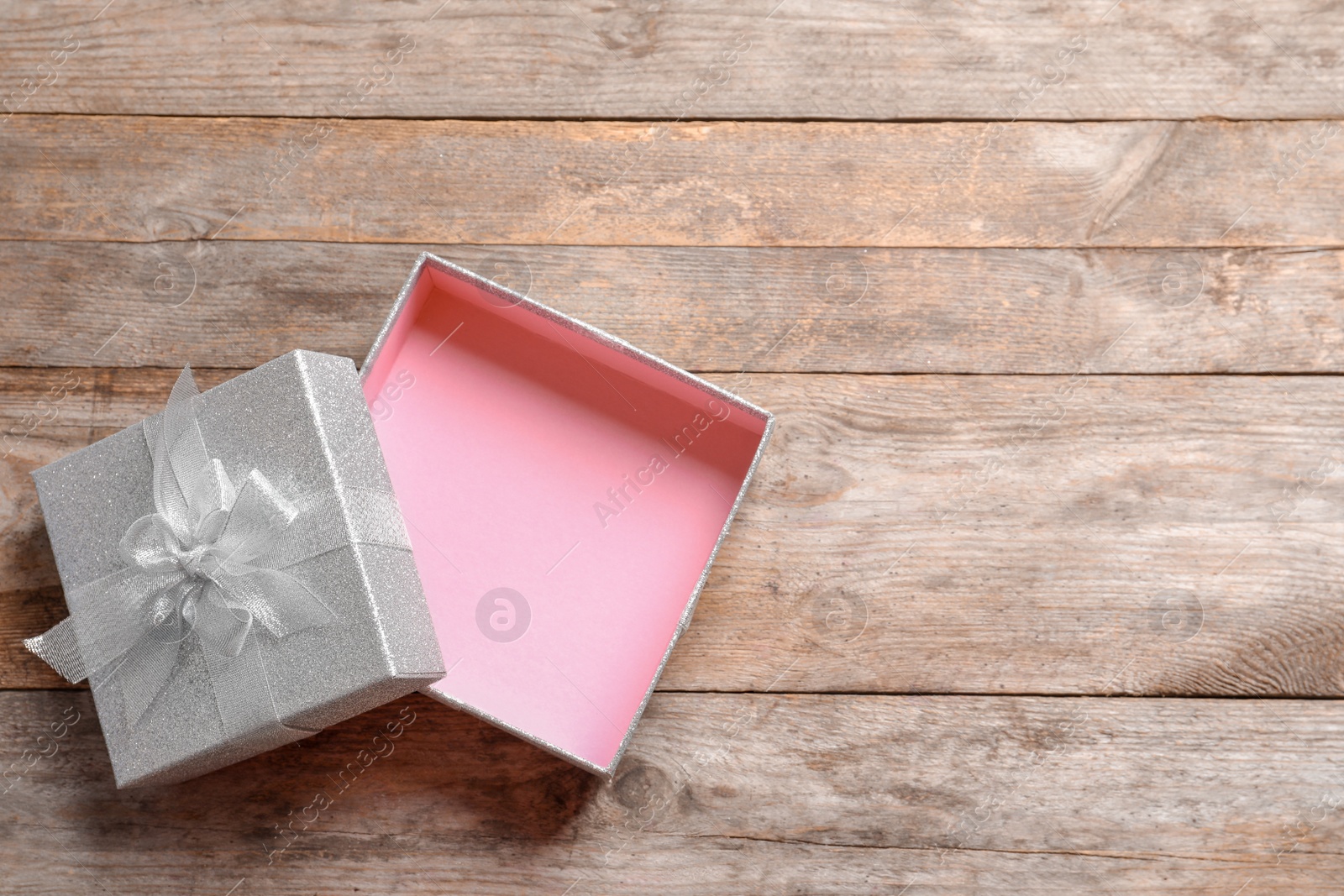 Photo of Empty open gift box on wooden background, top view