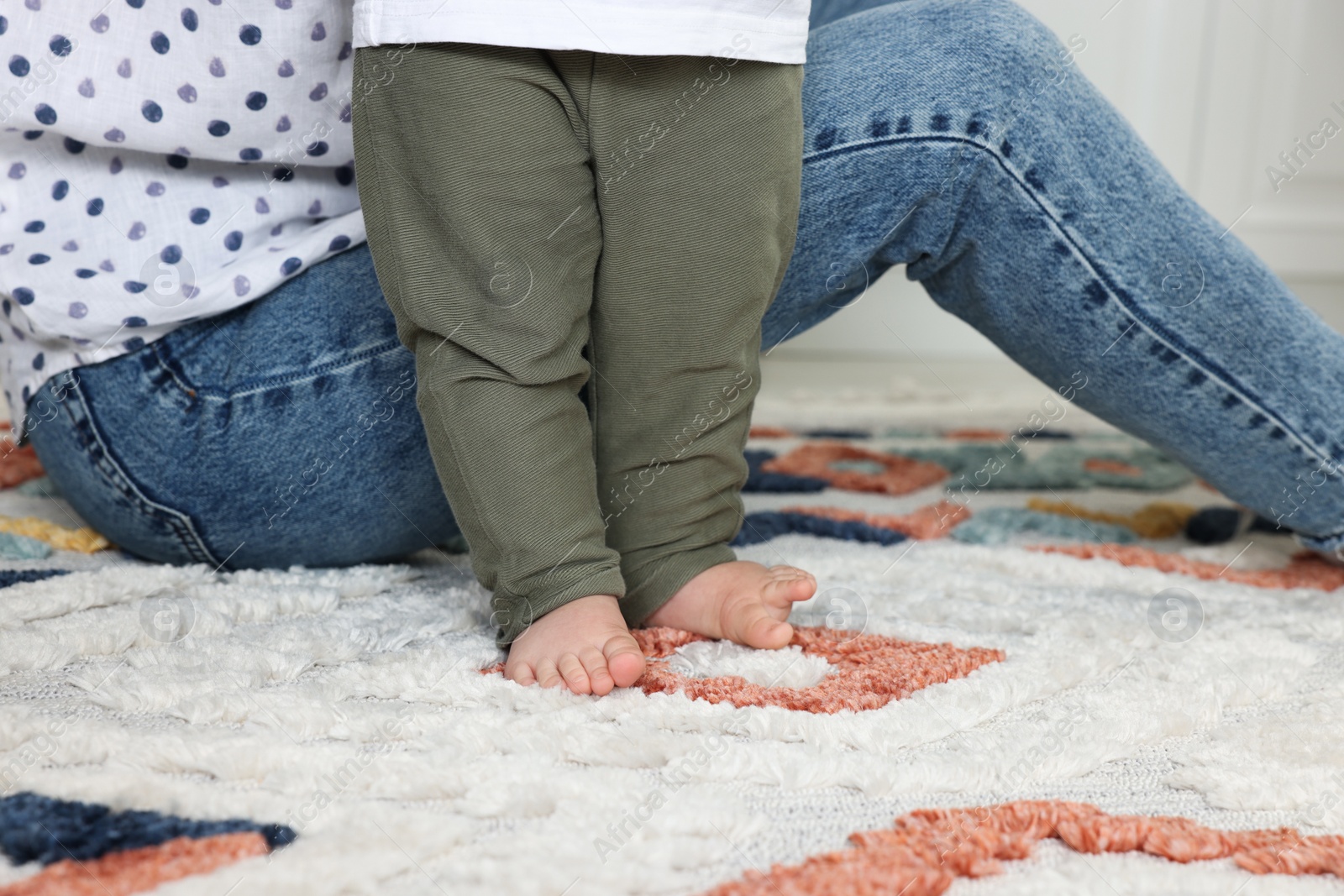 Photo of Mother with her son on soft carpet indoors, closeup