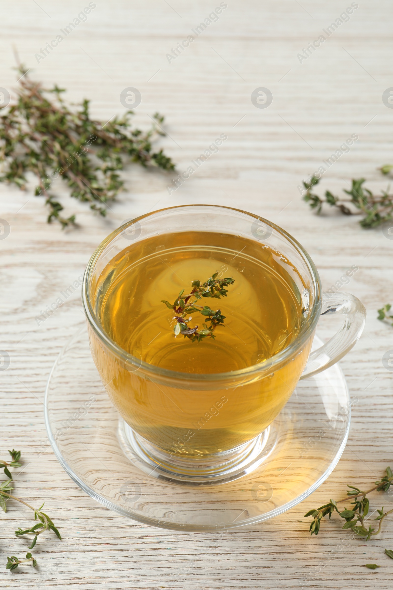Photo of Aromatic herbal tea with thyme on white wooden table