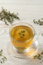 Aromatic herbal tea with thyme on white wooden table