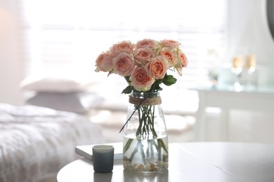 Glass vase with beautiful flowers on table in modern room interior