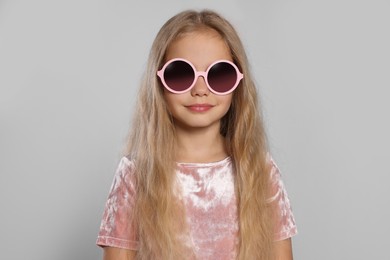 Photo of Girl in stylish sunglasses on light grey background