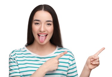 Photo of Happy woman showing her tongue and pointing at something on white background